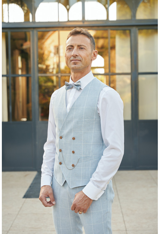 Homme portant le gilet PIANOSA bleu à carreaux accompagné d'un nœuds papillon.