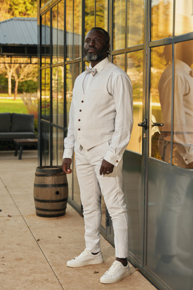 Homme portant le gilet LYMA blanc accompagné d'un nœuds papillon.