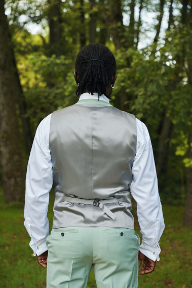 Homme de dos portant le gilet CHRIS vert d'eau. Il comporte une patte de serrage dans le dos.