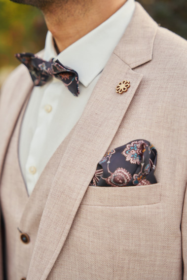 Costume GIORGIO rose pâle. Plan sur le nœuds  papillon à motif florale et le son mouchoir de poche.