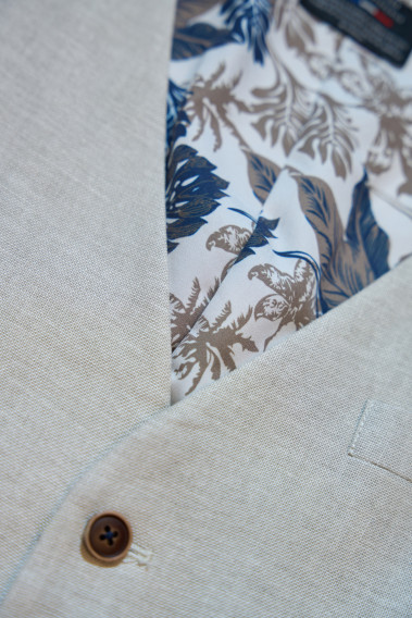 Zoom sur le gilet LYMAW beige. Il comporte 6 boutons et une chaine. L'intérieur comporte des motifs.