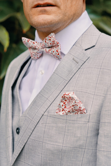 Costume SUAT gris à carreaux. Plan sur le nœuds  papillon à motif florale et son mouchoir de poche.