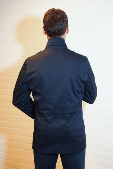Homme de dos portant la Parka ANNA marine. Elle comporte un cordon de serrage.