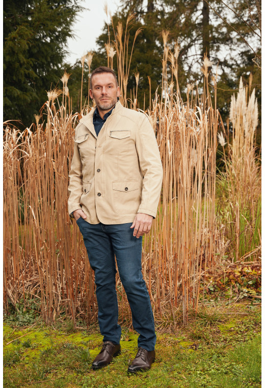 Homme portant la saharienne  BELLANI beige. Elle comporte 2 poches poitrine et 2 poches à rabat.