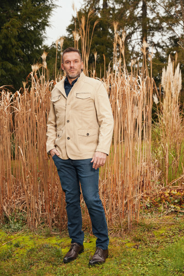 Homme portant la saharienne  BELLANI beige. Elle comporte 2 poches poitrine et 2 poches à rabat.