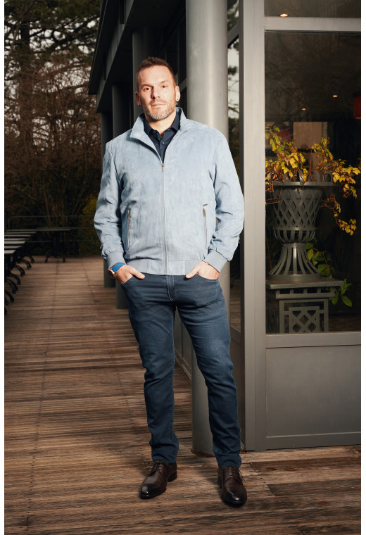 Homme portant le blouson suédine DAWKYN bleu-gris. Il comporte 2 poches verticales.