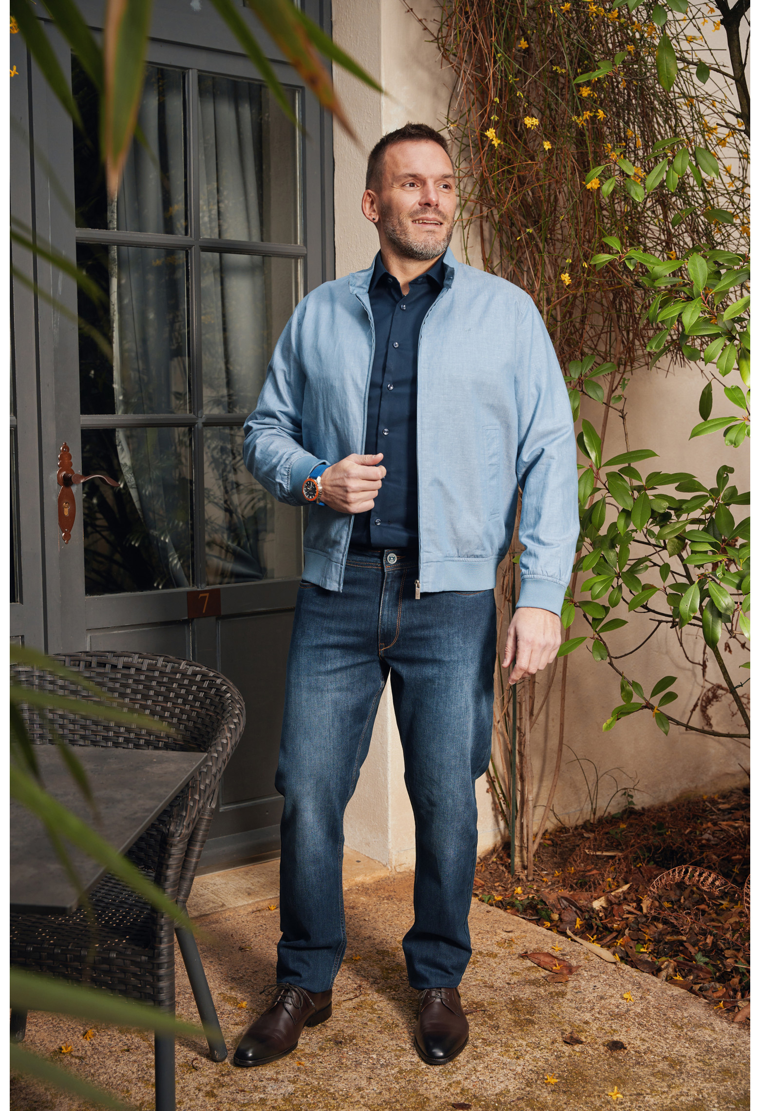 Homme portant le blouson lin HANOT bleu clair. Il comporte 2 poches cotés repose mains.