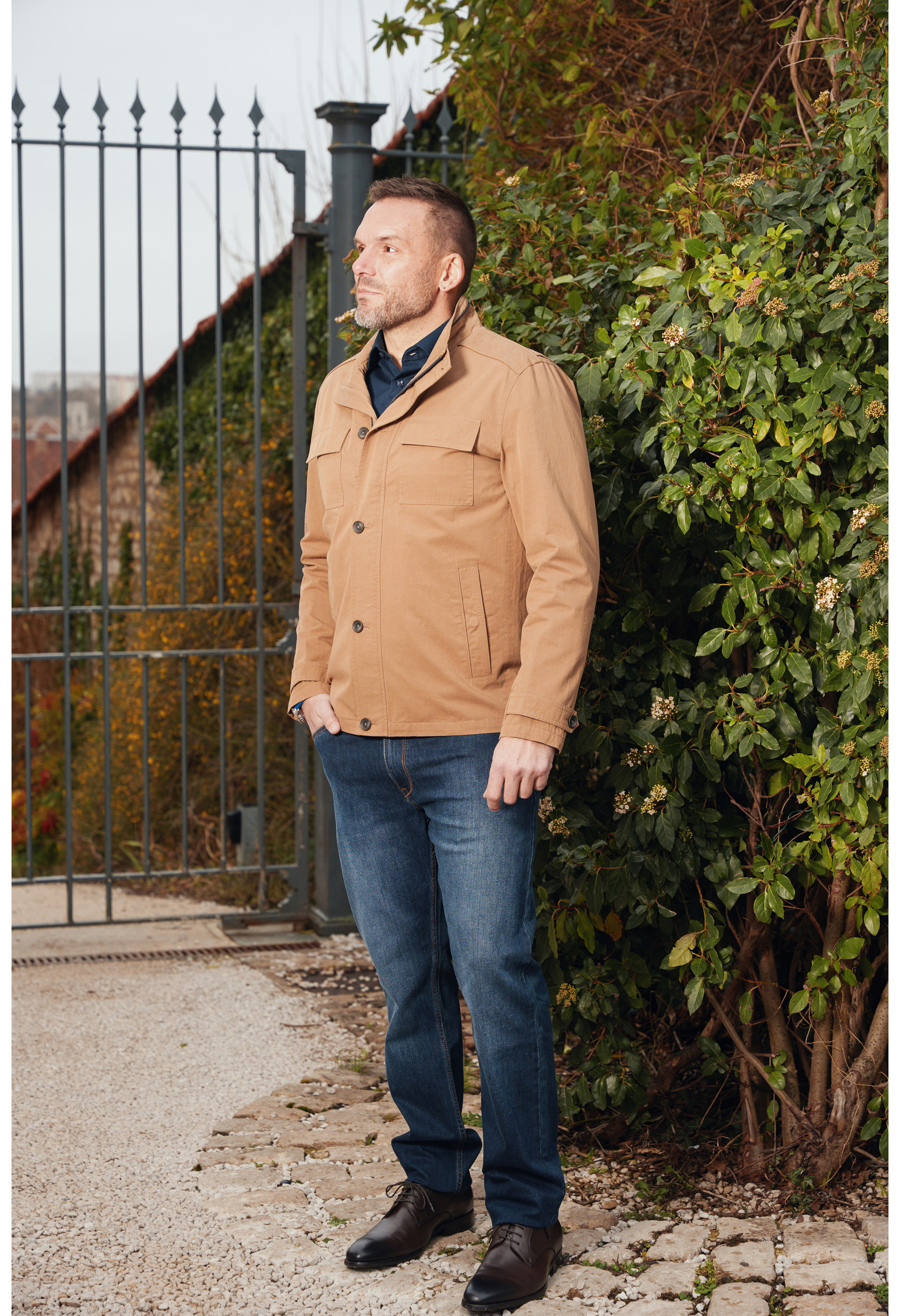 Homme portant le blouson coton LENA camel. Il comporte 2 poches poitrine et 2 poches verticales.