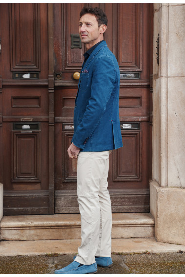 Homme de profil portant la veste MOLY jean. Elle comporte 2 poches poitrine et 2 poches à rabat.