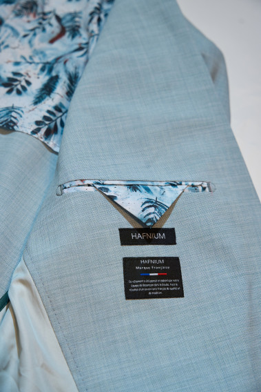 Costume OLIVER vert lagon, intérieur de la veste avec étiquette Hafnium et motif intérieur feuille bleu vert sur fond blanc.