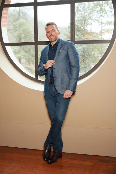 Homme portant la veste OLIVIA bleue. Elle comporte une poches poitrine et 2 poches plaquées.