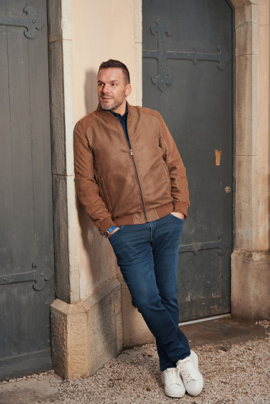 Homme portant le blouson suédine OLIVIER camel. Il comporte 2 poches repose mains.