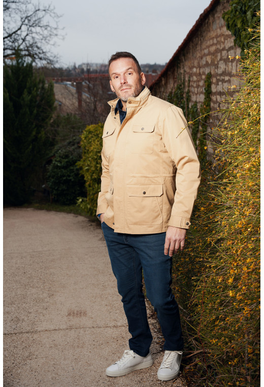 Homme portant la parka RIMINI beige. Elle comporte 2 poches poitrine, 2 poches plaquées à rabat.