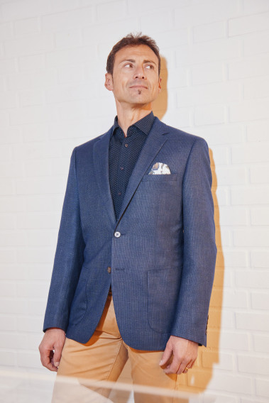 Homme portant la veste SELENA effet maille marine. Elle comporte une poche poitrine et 2 poches plaquées.