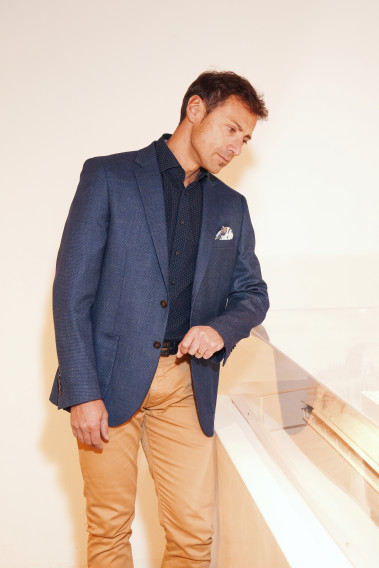 Homme portant la veste SELENA effet maille marine. Elle comporte une poche poitrine et 2 poches plaquées.