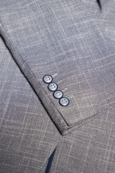 Zoom sur la manche de la veste SELENA bleue. Elle comporte 4 boutons.