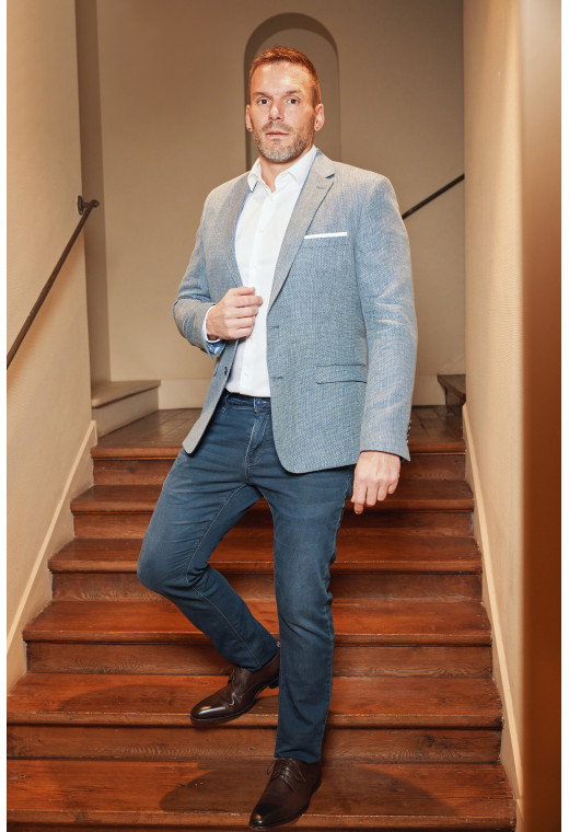 Homme portant la veste SUATV bleu. Elle comporte une poches poitrine et 2 poches à rabat.