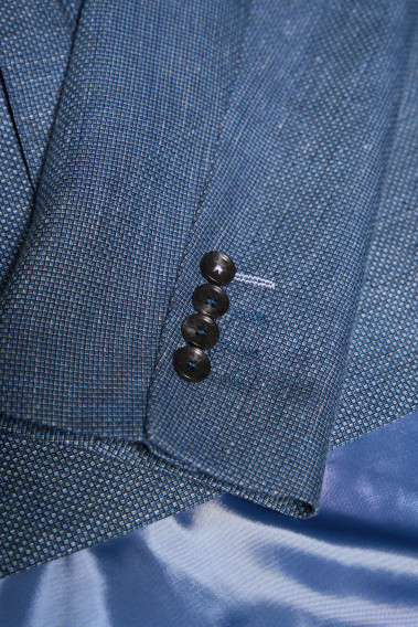 Zoom sur la manche de la veste SUATV bleu. Elle comporte 4 boutons.