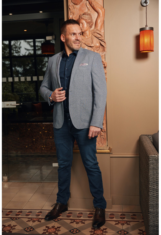 Homme portant la veste VALENTINA bleu foncé. Elle comporte une poches poitrine et 2 poches plaquées.