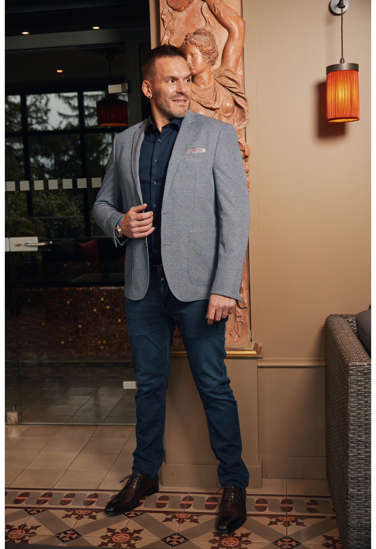 Homme portant la veste VALENTINA bleu foncé. Elle comporte une poches poitrine et 2 poches plaquées.