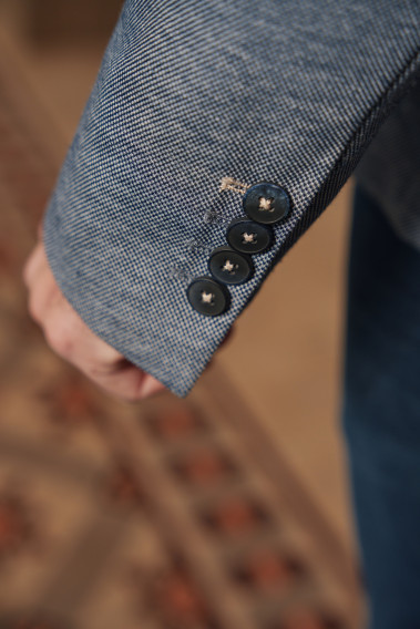 Zoom sur la manche de la veste VALENTINA bleu foncé. Elle comporte 4 boutons.