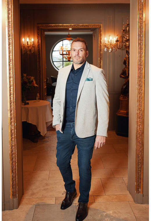 Homme portant la veste VALENTINA grise. Elle comporte une poches poitrine et 2 poches plaquées.