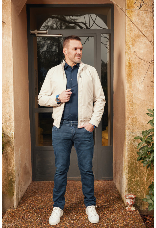 Homme portant le blouson WEMBLEY beige. Il comporte une poche poitrine et 2 poches avec fermeture éclaire.
