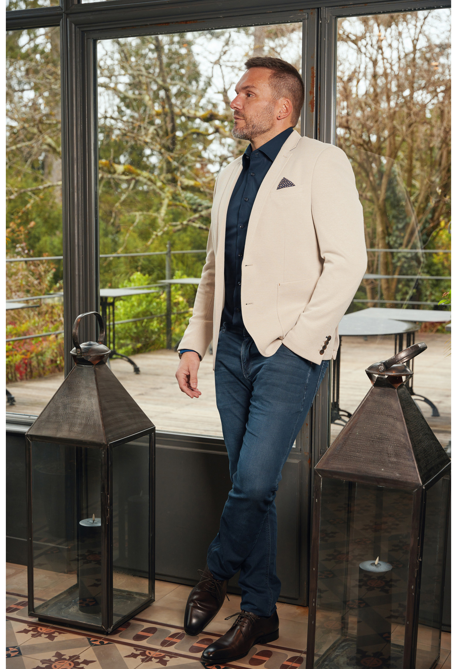 Homme portant la veste VALENTINA beige. Elle comporte une poches poitrine et 2 poches plaquées.