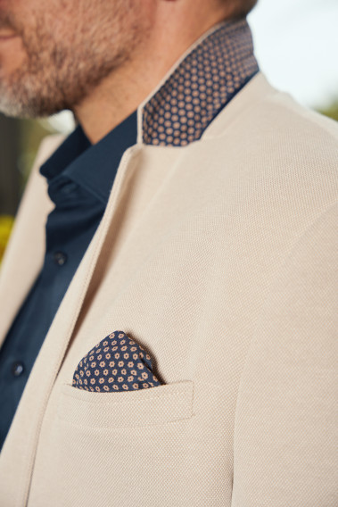 Zoom sur le dessous de col et le mouchoir de poche de la veste VALENTINA beige.