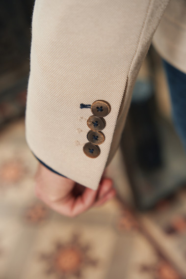 Zoom sur la manche de la veste VALENTINA beige. Elle comporte 4 boutons.