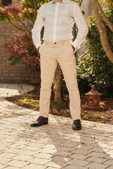 Homme portant le pantalon LINCOLN beige. Il comporte 3 poches avant et 2 poches arrière.