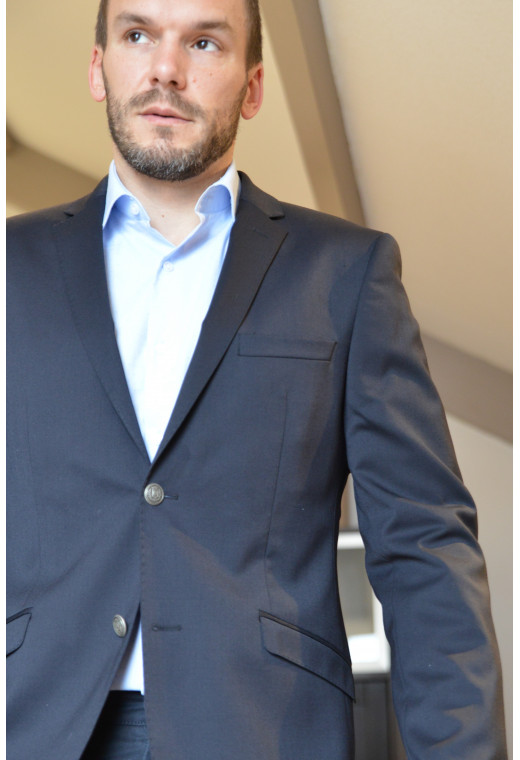 Homme portant le blazer BOLTON marine. Il comporte une poche poitrine et 2 poches à rabat.