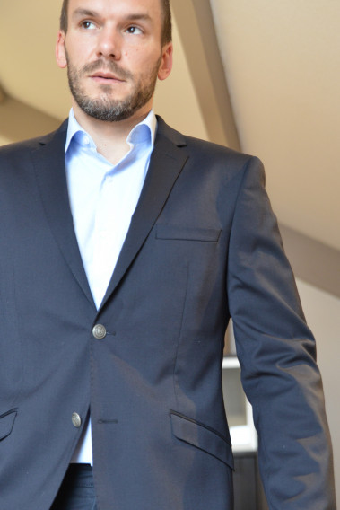 Homme portant le blazer BOLTON marine. Il comporte une poche poitrine et 2 poches à rabat.