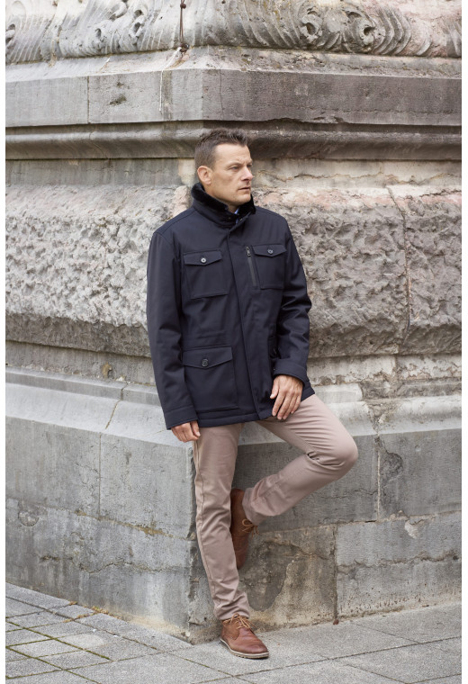 Homme portant la surveste TESS marine. Elle comporte 5 poches.