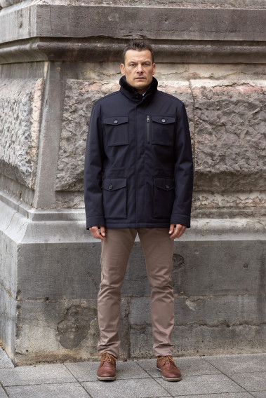 Homme portant la surveste TESS marine. Elle comporte 5 poches.