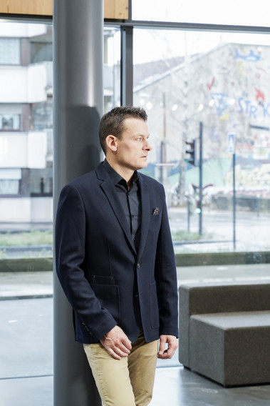 Homme portant la veste slim effet maille marine. Elle comporte une poche poitrine et 2 poches plaquées.