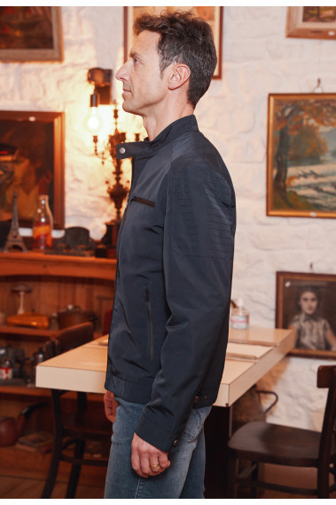 Homme de profil portant le blouson ALPHA marine. Il comporte 2 poches de poitrine et 2 poches verticales.