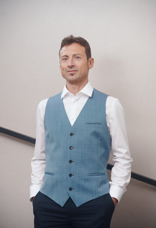 Homme portant le gilet .CHRIS bleu accompagné d'une chemise blanche.