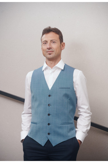 Homme portant le gilet .CHRIS bleu accompagné d'une chemise blanche.