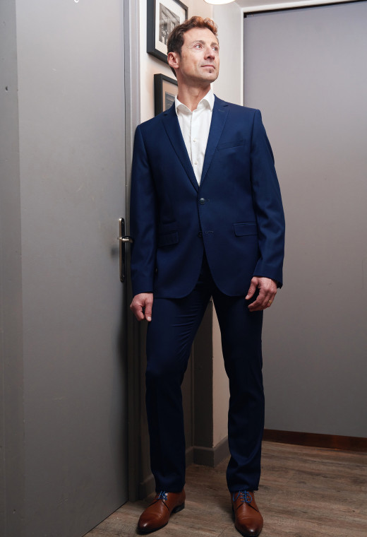 Homme portant le pantalon DIANA bleu. Il comporte 2 poches avant et 2 poches arrière.