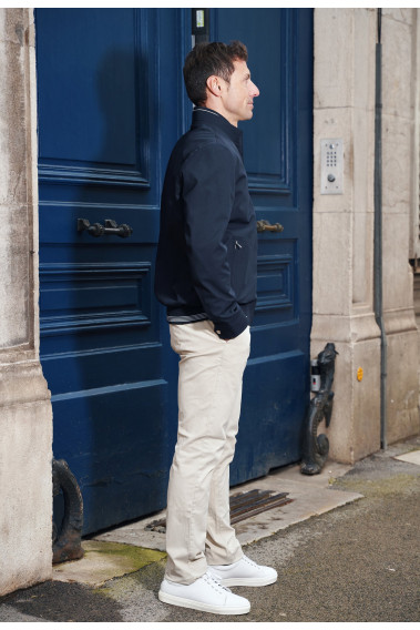 Homme de profil portant le blouson EAMOND marine. Il comporte 2 poches repose mains.