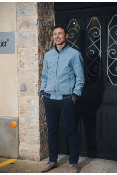 Homme portant le blouson  JUMBO bleu clair. Il comporte 2 poches repose mains.