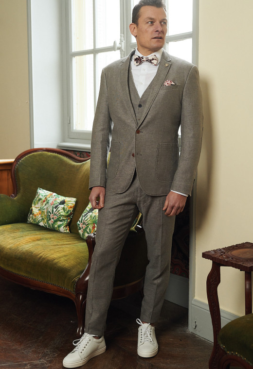 Homme portant le pantalon LINCOLN taupe. Il comporte 3 poches avant et 2 poches arrière.