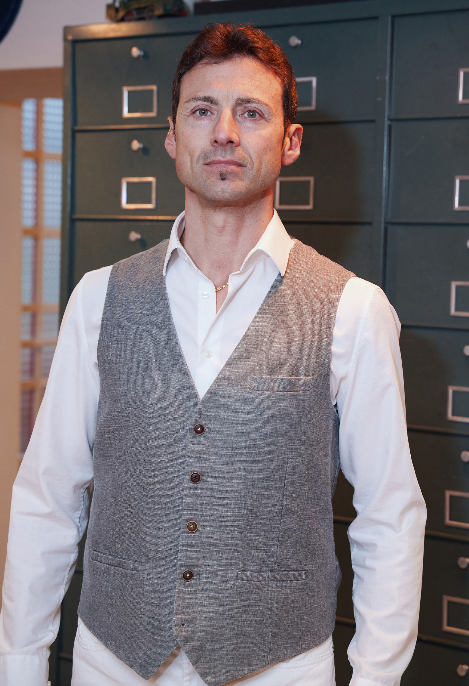 Homme portant le gilet LYMA taupe accompagné d'une chemise blanche.