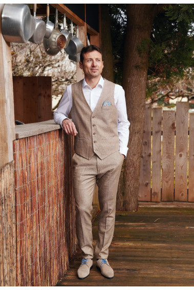 Homme portant le gilet  LYMA sable accompagné d'une chemise blanche et d'un mouchoir de poche.