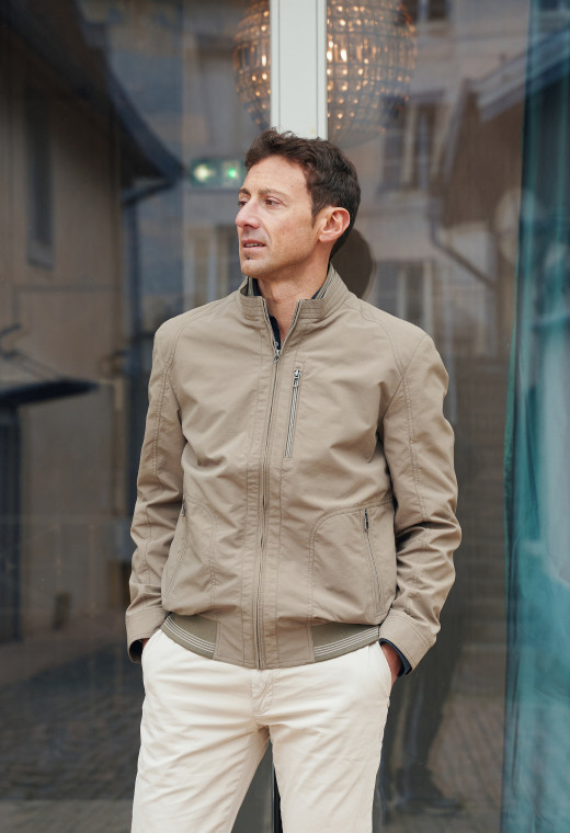 Homme portant le blouson  NINA kaki. Il comporte une poche poitrine et  2 poches repose mains.