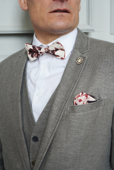Zoom sur la veste SAFARY taupe. L'homme porte une nœuds papillon et un mouchoir de poche.