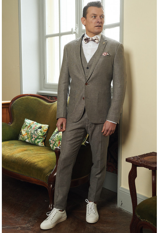 Homme portant la veste SAFARY taupe. Elle comporte une poche poitrine et 2 poches  plaquées.