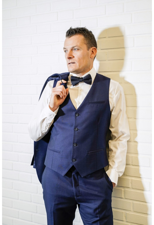 Homme portant le gilet CHRIS bleu accompagné d'un nœuds papillon.