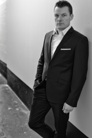 Homme portant la veste SULTAN noire. Elle comporte une poche poitrine et poches rabats.